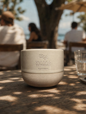Espressotasse Ocean Mug in Salt auf einem Cafétisch mit Meerblick