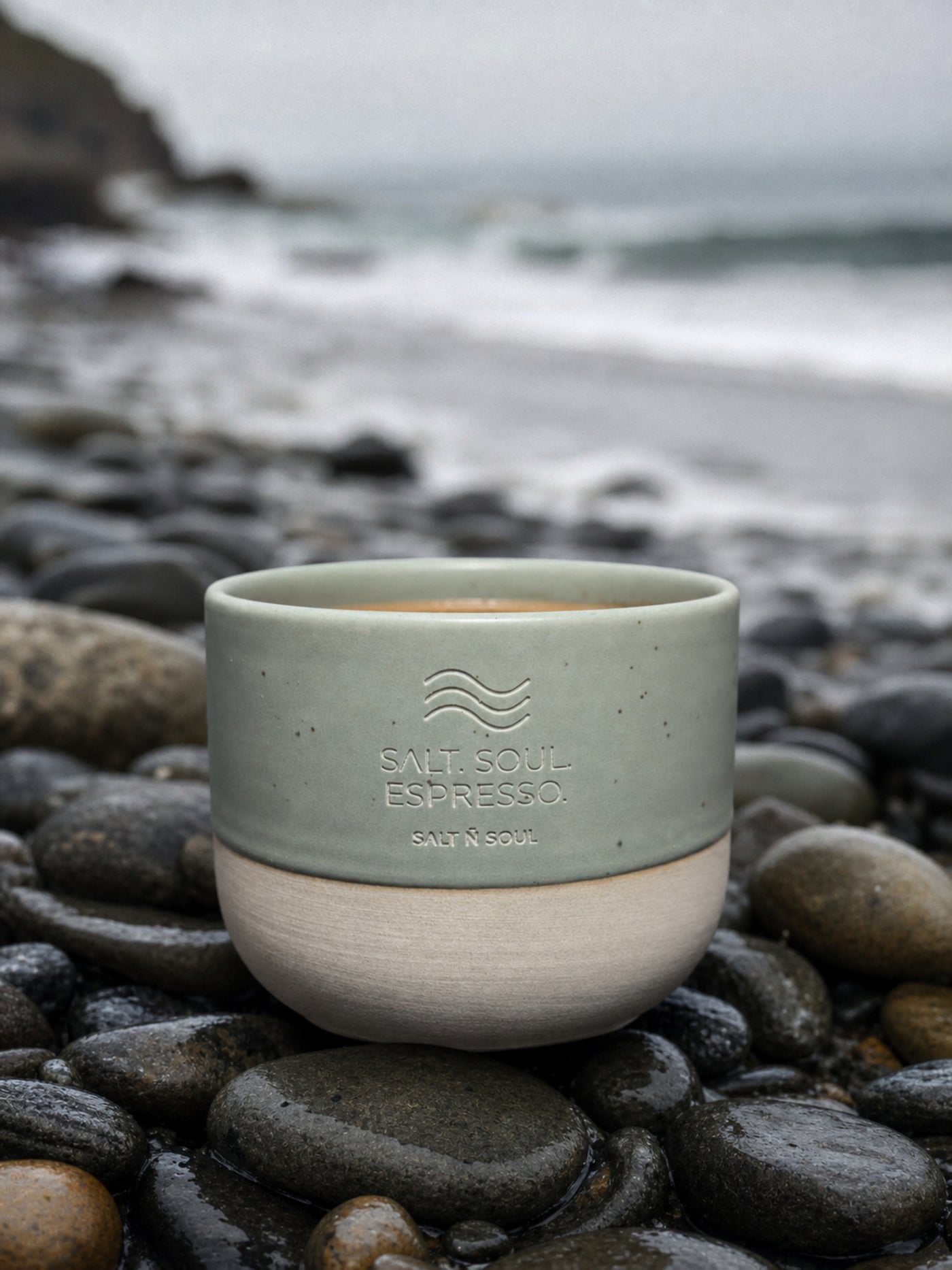 Ocean Mug in Seagrass auf Kieselsteinen am Strand
