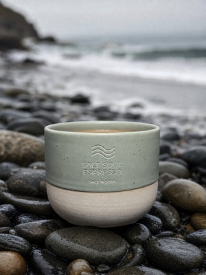 Ocean Mug in Seagrass auf Kieselsteinen am Strand
