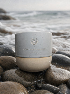 Ocean Mug in Coastal Fog mit gravierten Emblem am Steinstrand