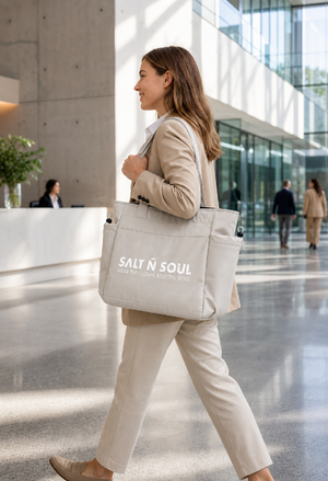 Frau im Business-Look trägt TideCarry Tote Bag von SALT Ñ SOUL in Shell durch eine moderne Bürolobby